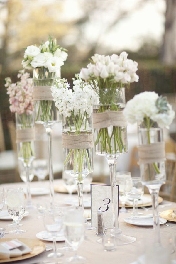 assorted wild white flowers in tall stemmed candle holders wrapped with burlap wedding centerpiece